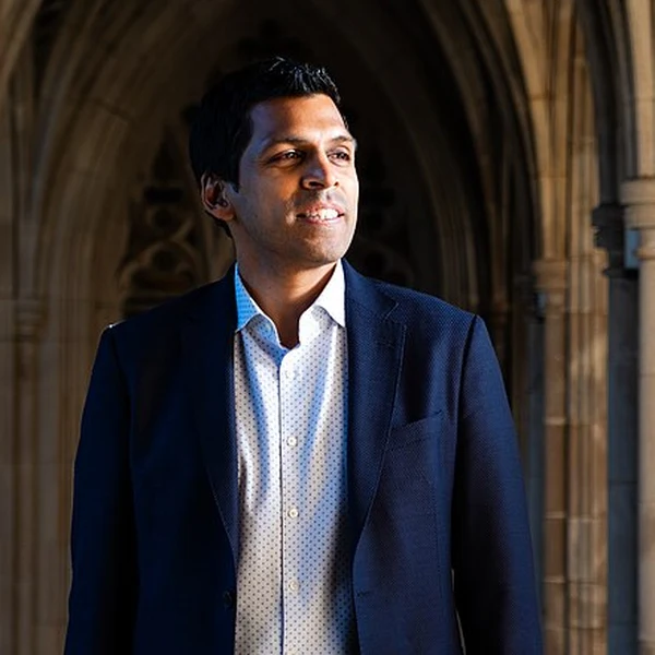 Aaron Chatterji, an economist at OpenAI, standing in a stone cloister at Duke University